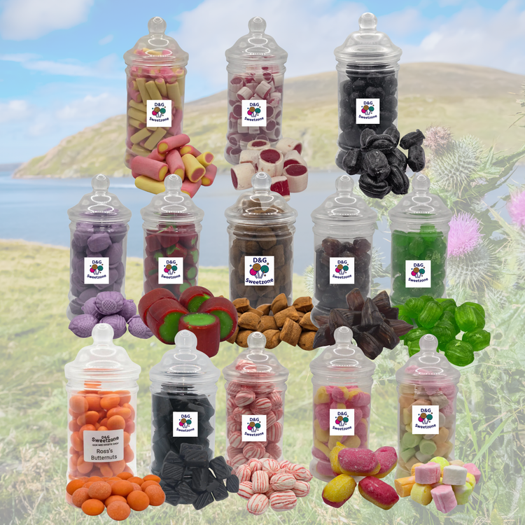 Two clear plastic candy jars with glass stoppers on a white background, with pink and yellow cylindrical candies spilled in front of the left jar and pink candy pieces spilled in front of the right jar. Both jars have D&G Sweetcorn labels.
