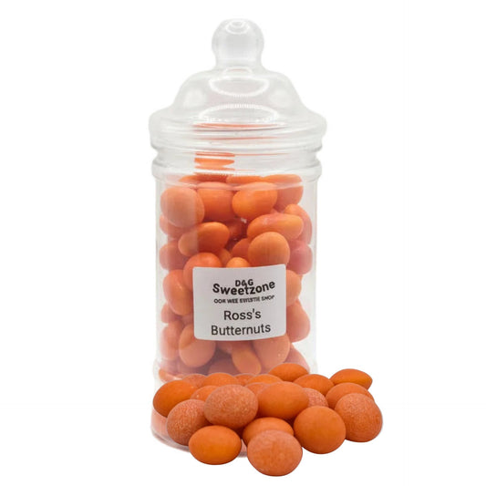 A clear glass jar with a lid containing orange butternut candies, labeled 'D&G Sweetzone' and 'Rosss Butternuts', on a white background.