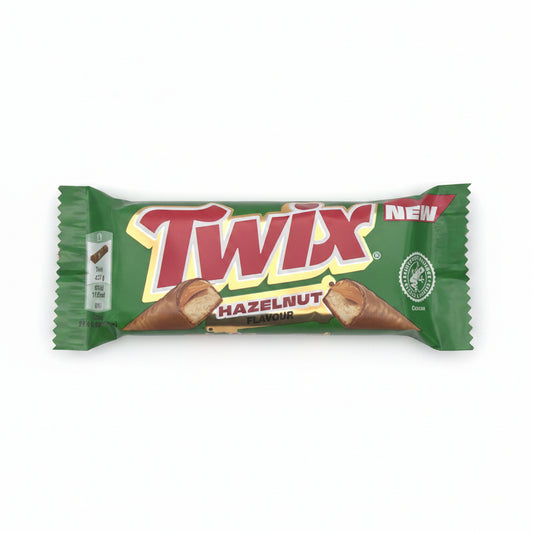 A Twix Hazelnut Butter bar in its original green wrapper, featuring the red and white Twix logo and an illustration of a hazelnut cookie, set against a plain light gray background.